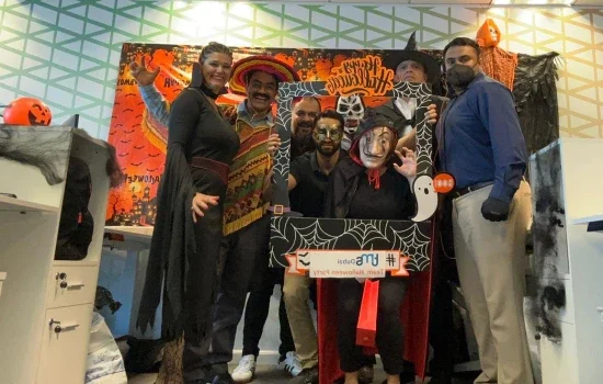 tms Dubai colleagues posing for a photo in front of Halloween decorations during their Halloween party