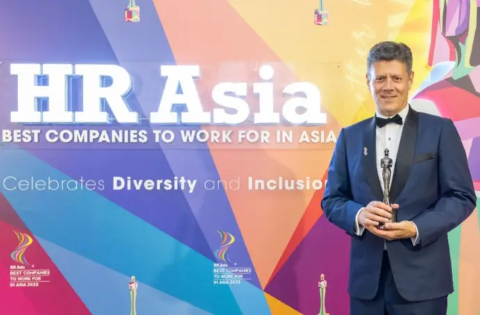 Tony holding award in front of "HR Asia" sign