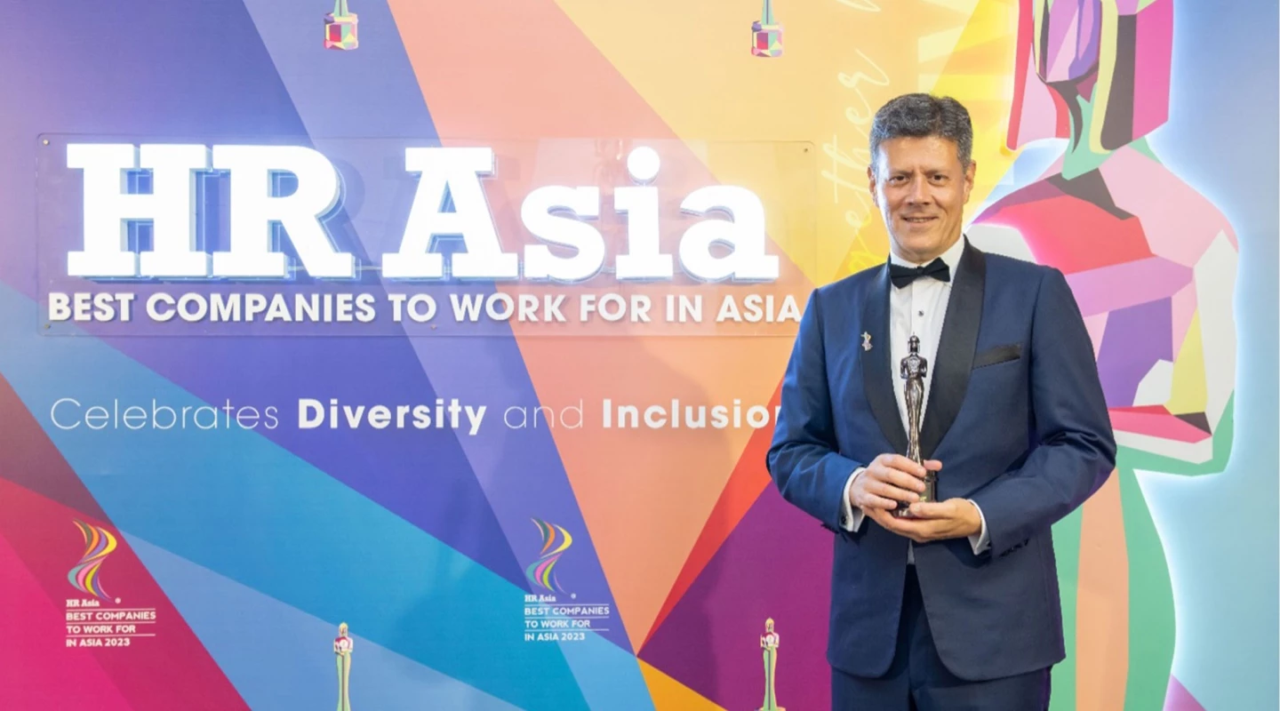 Tony holding award in front of "HR Asia" sign