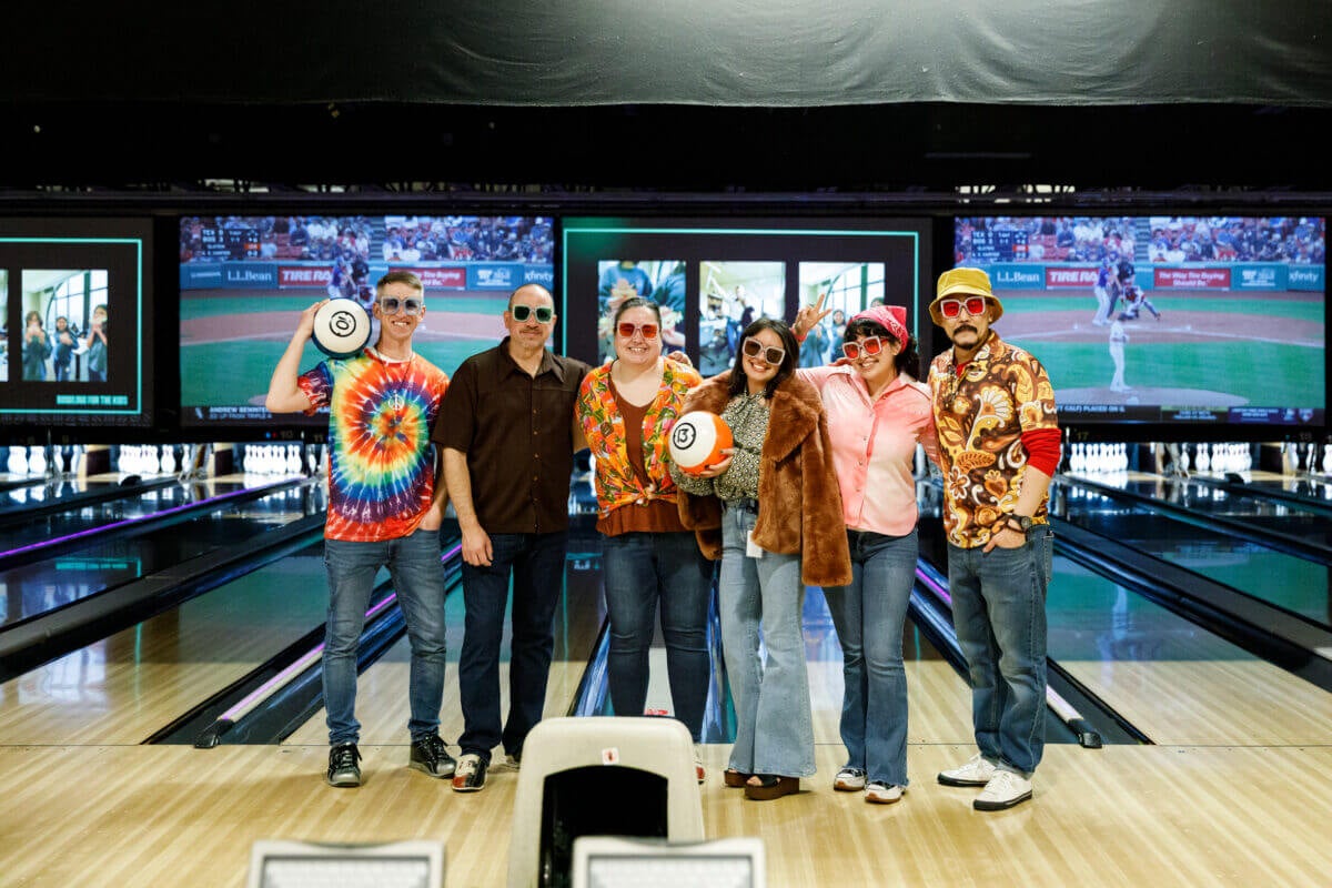 tms colleagues posing for a photo in a bowling alley