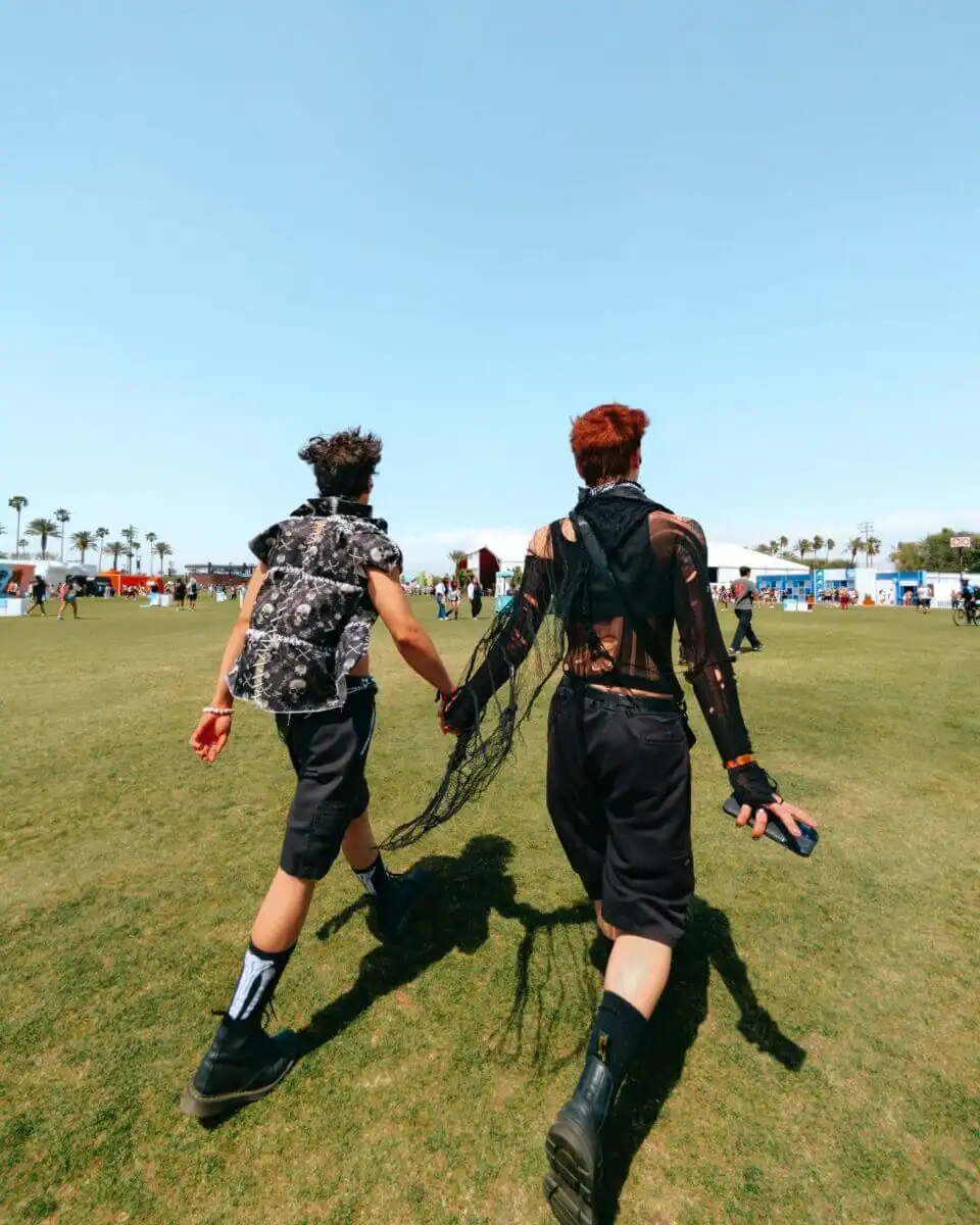Two people holding hands at a festival