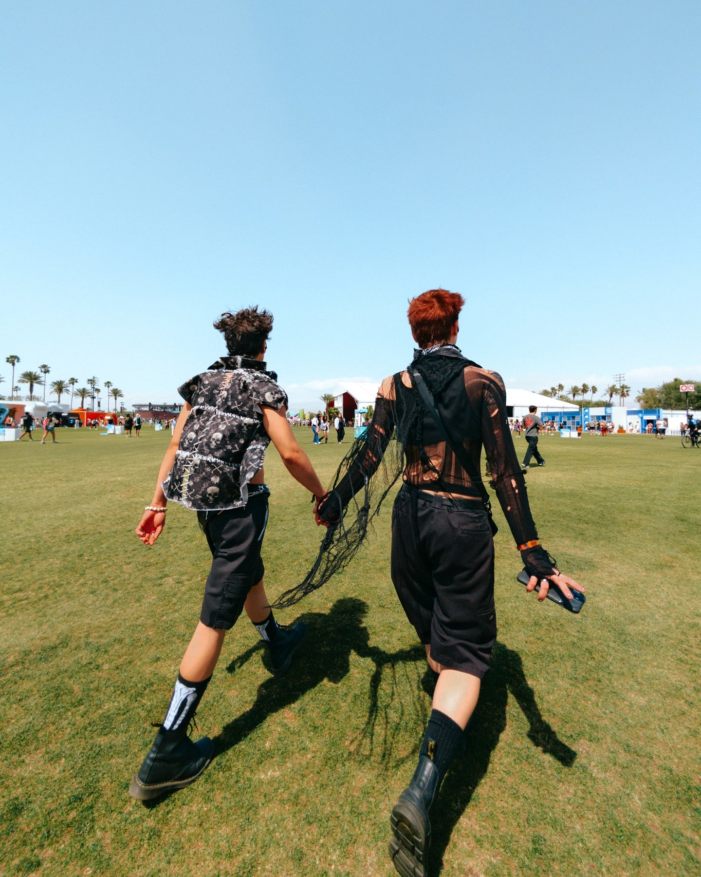 Two people holding hands at a festival