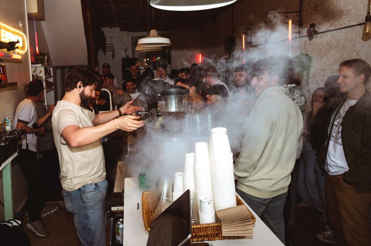A large party at a coffee shop with a barista on the left