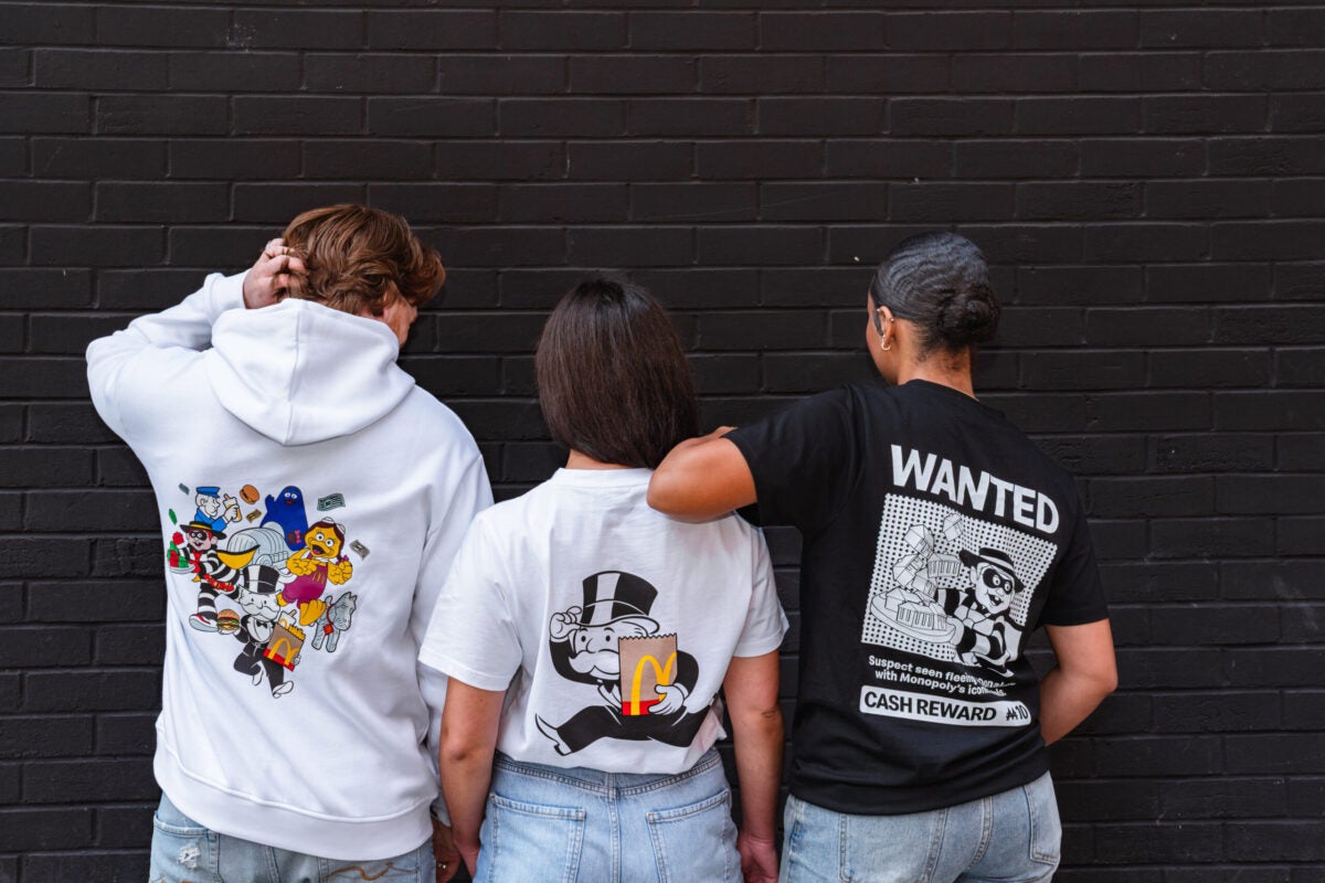 Trois personnes portant des produits dérivés McDonald's Monopoly