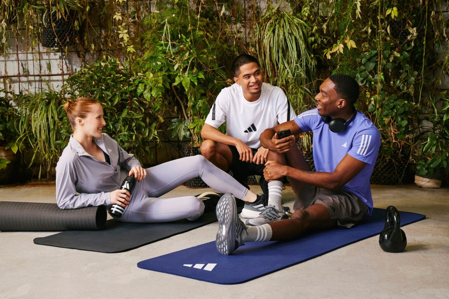 group of people sitting on yoga matts laughing