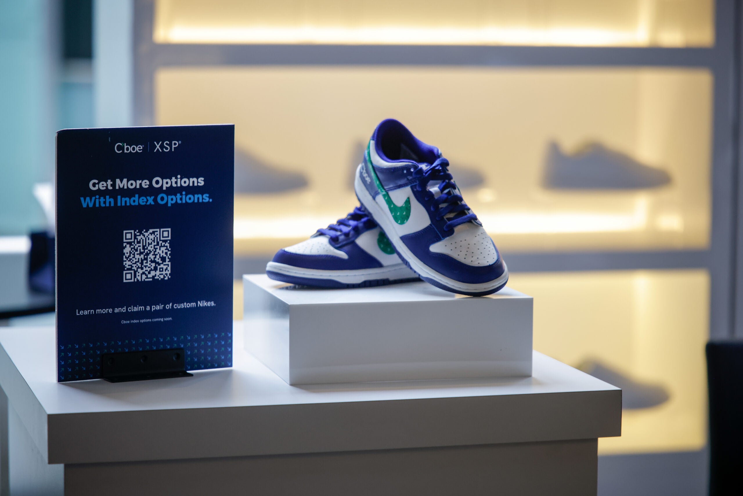 Nike trainers on stand with Cboe Index Options QR code