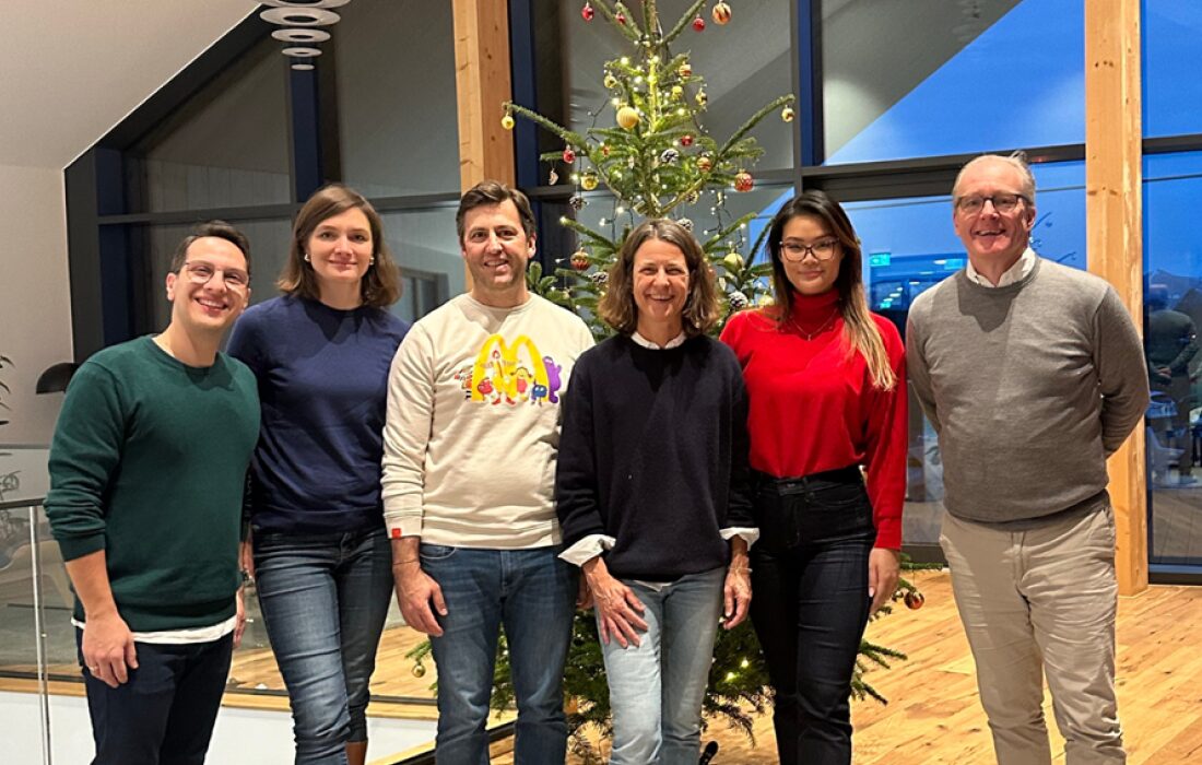 6 people standing for a photo in front of a christmas tree in Germany
