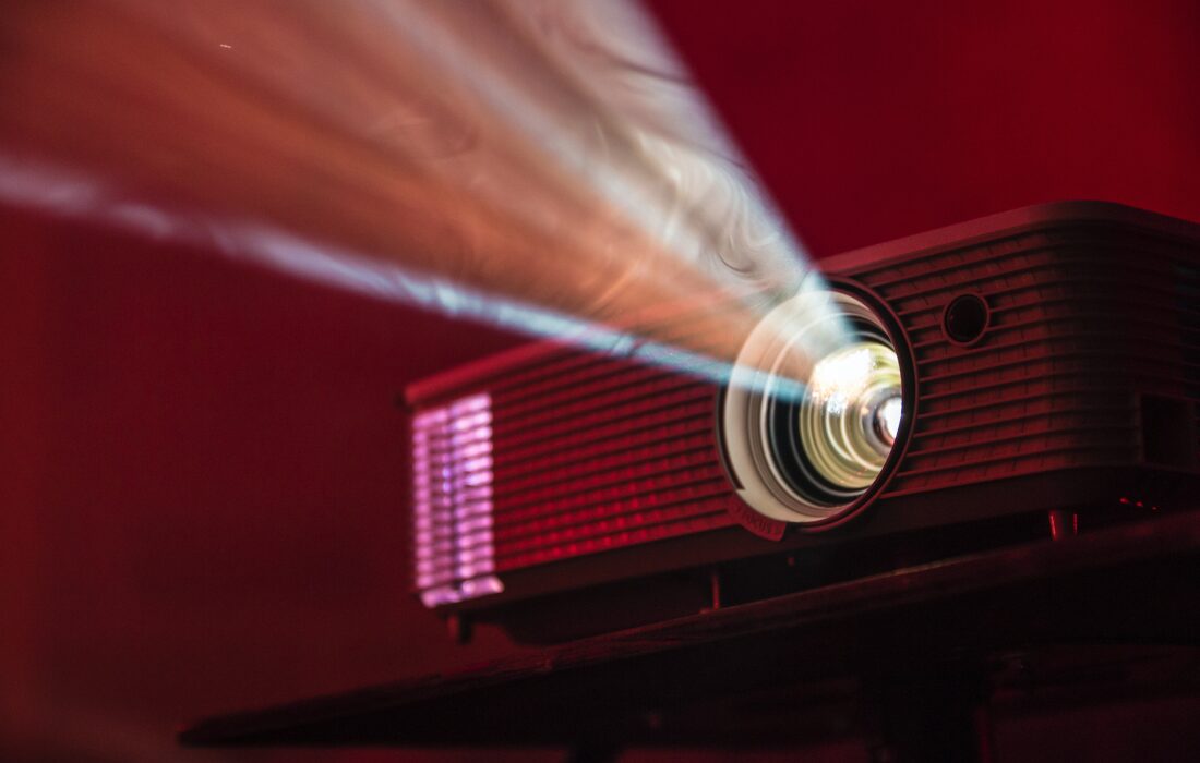 An image of a projector illuminated with a red background