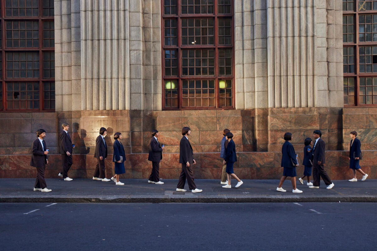 still from Cboe TV advert men with same haircut walking along street
