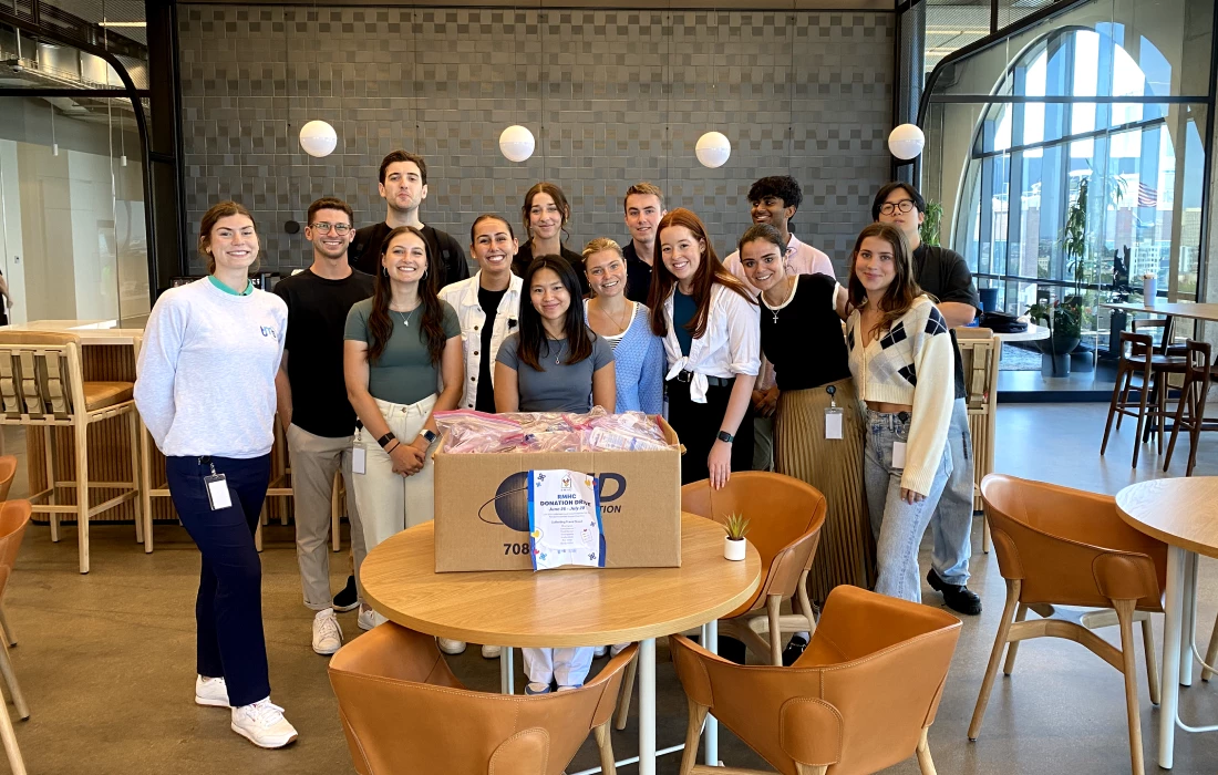 a group of people posing smiling for a picture in an office