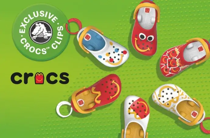 Fond vert avec le logo Crocs x McDonald’s et 6 jouets Crocs disposés en cercle