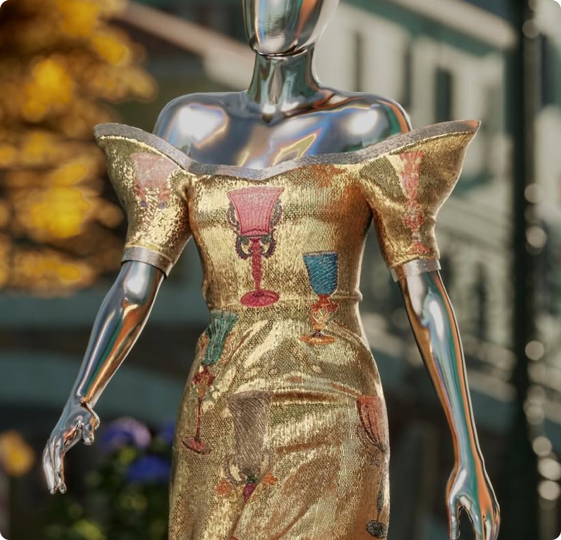 Metallic mannequin wearing a gold off shoulder dress decorated with colorful goblet motifs