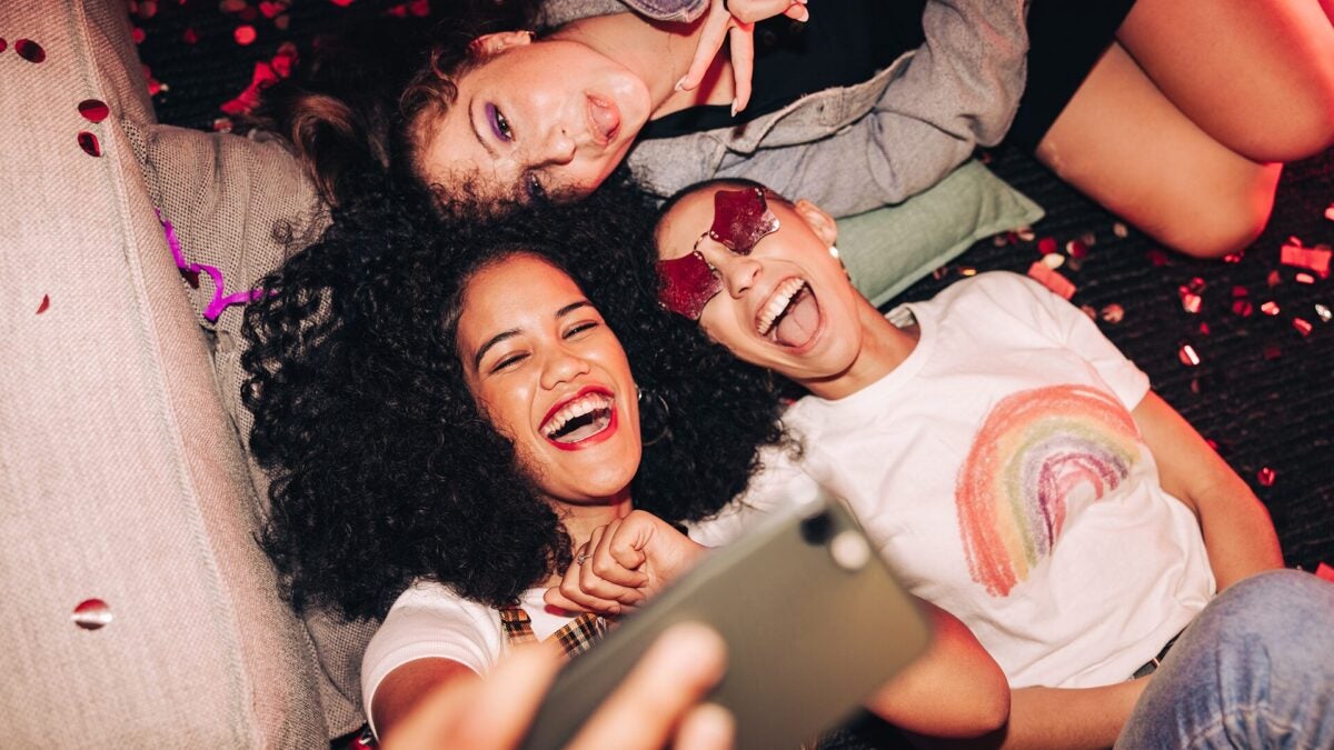 A group of women posing for a selfie smiling