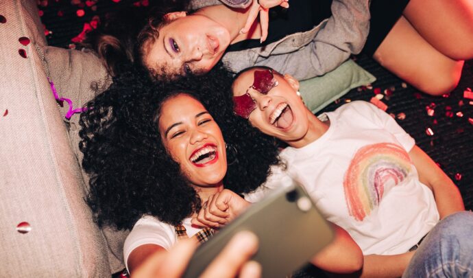 A group of women posing for a selfie smiling