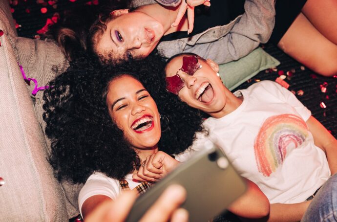 A group of women posing for a selfie smiling