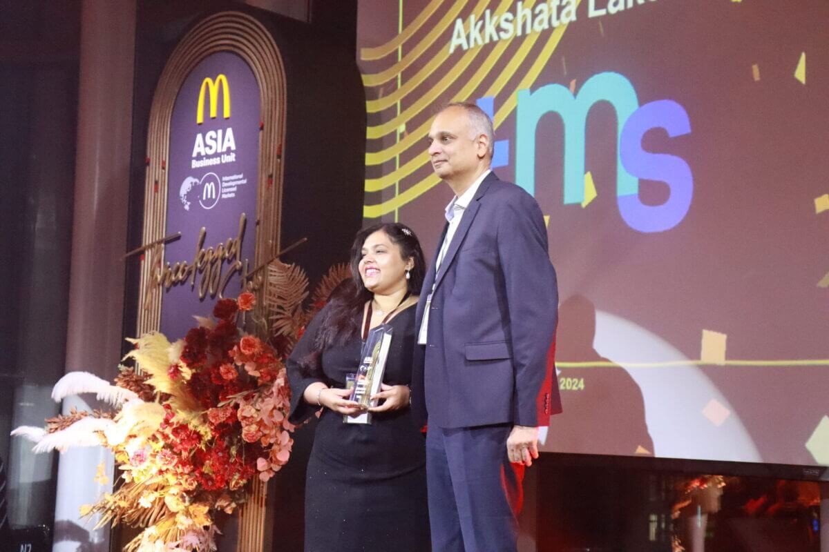 Deux personnes sur scène avec un trophée