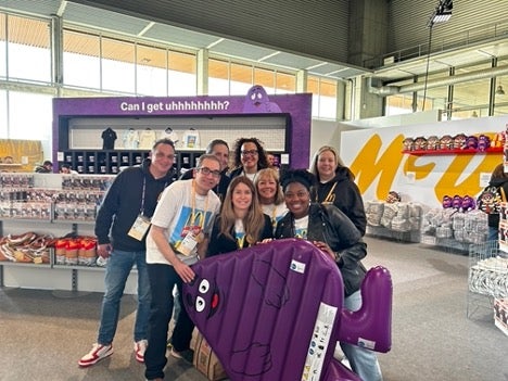 Groupe de collaborateurs tms gérant le Fandom Store posant avec un jouet Grimace