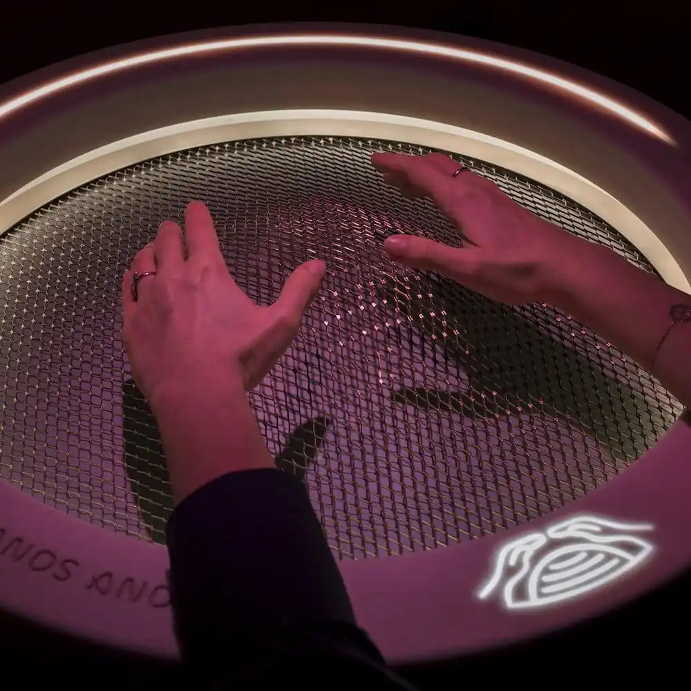 hands hovering over a mesh sphere