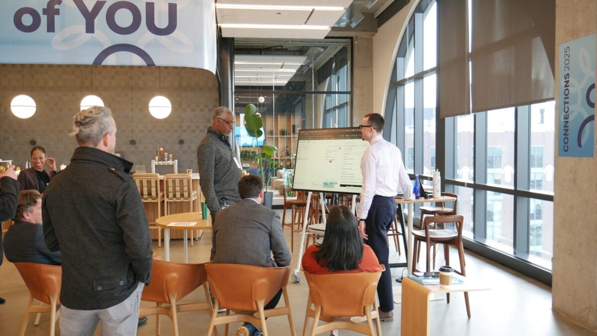 People interacting with a screen in a small breakout group