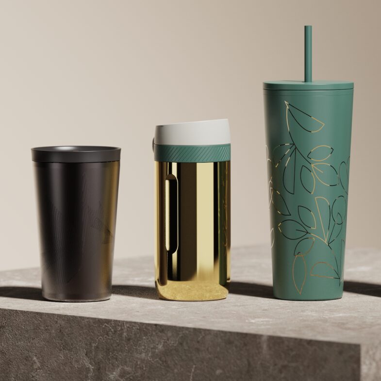 Three pieces of drinkware — one black tumbler, one gold, one green