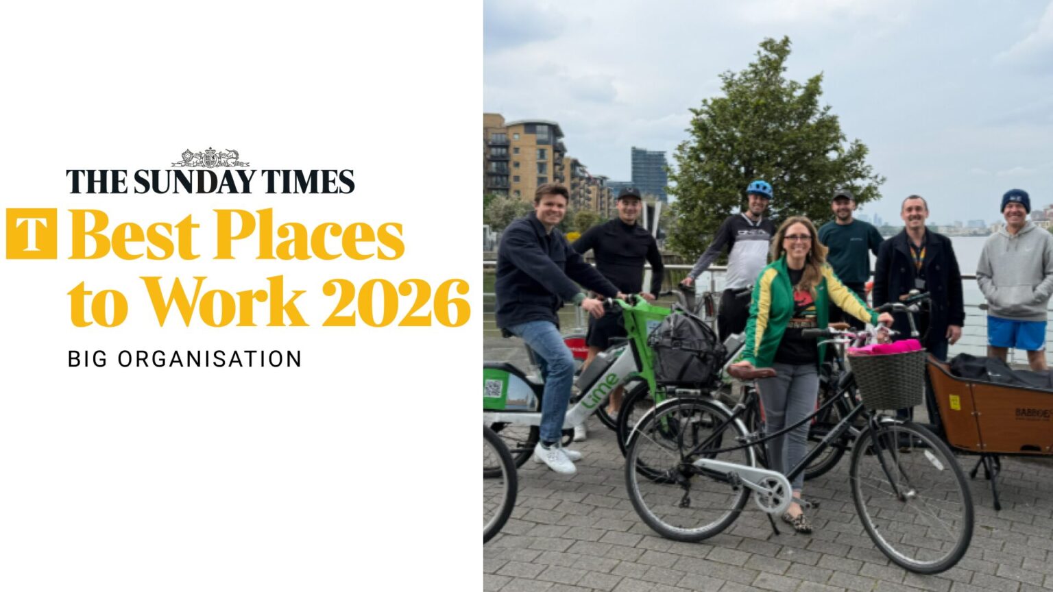 Group of people posing with bikes with the Sunday Times Best Places to Work logo on the left