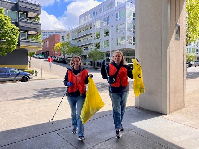 Two women cleaning up garbage