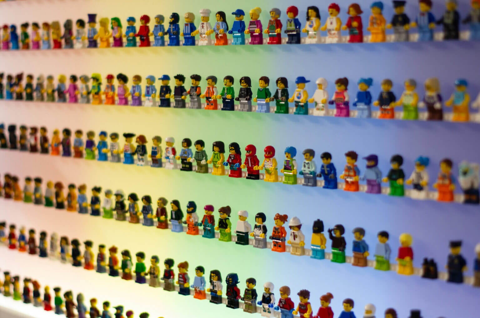 over a hundred lego minifigures lined up on shelves