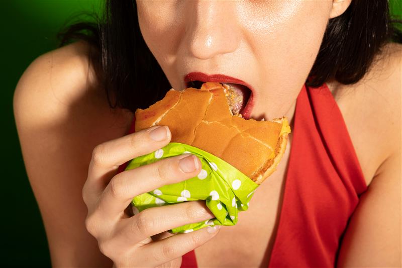 girl in red top eating burger