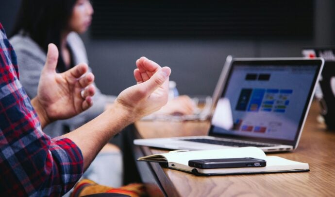 A person moving their hands in front of a computer screen