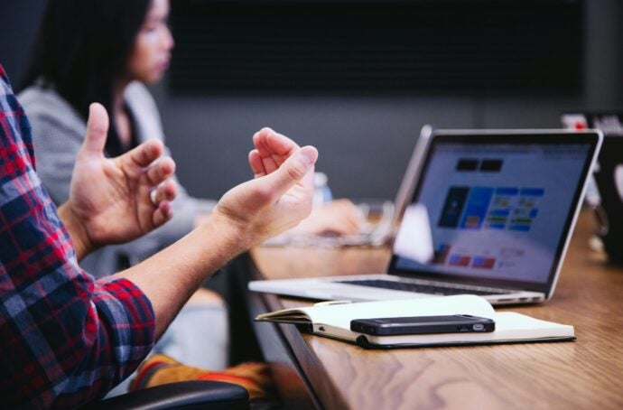 A person moving their hands in front of a computer screen