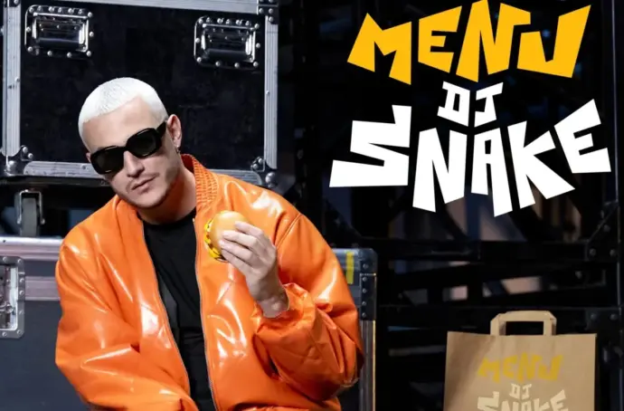 DJ Snack holding a hamburger next to his Famous Order meal