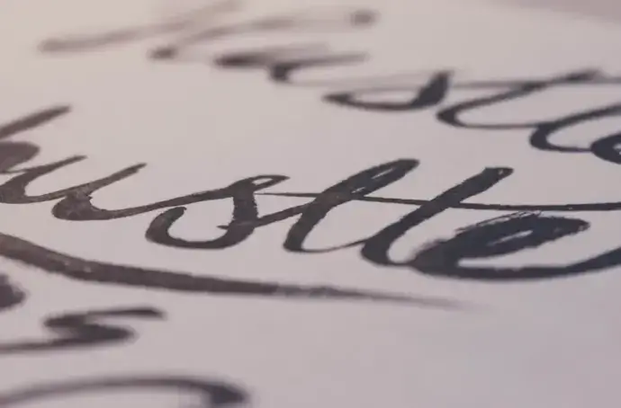 the word hustle in cursive