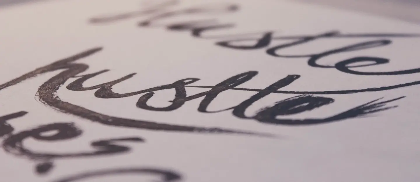 the word hustle in cursive