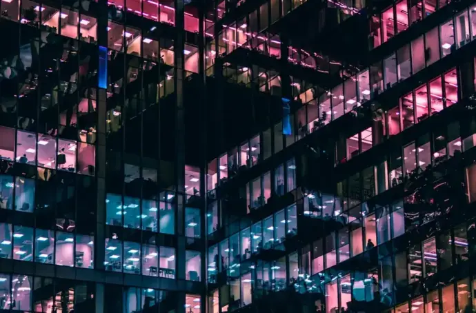 Office building at night with blue, pink, and purple colored windows