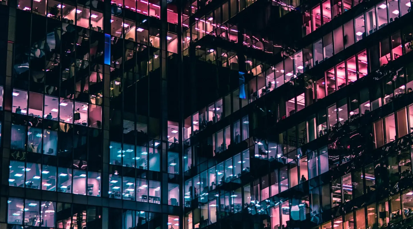 Office building at night with blue, pink, and purple colored windows