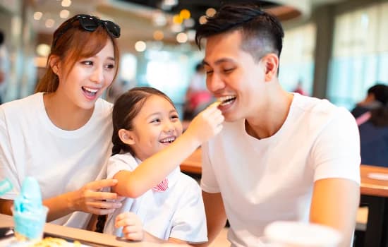 Family of three enjoys French fries at McDonald's