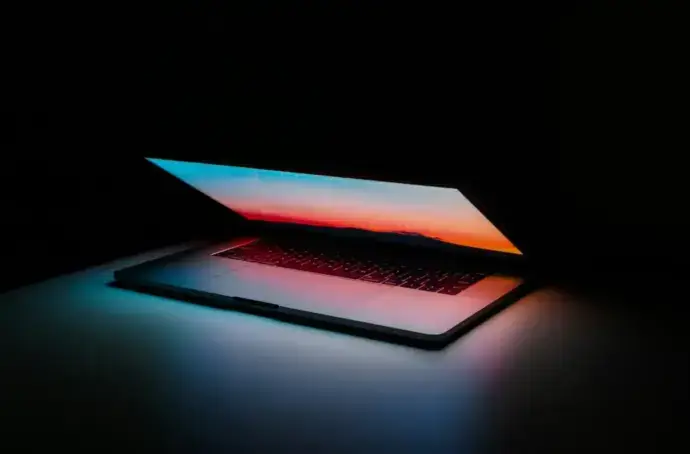 Open laptop with colorful screensaver against a black background
