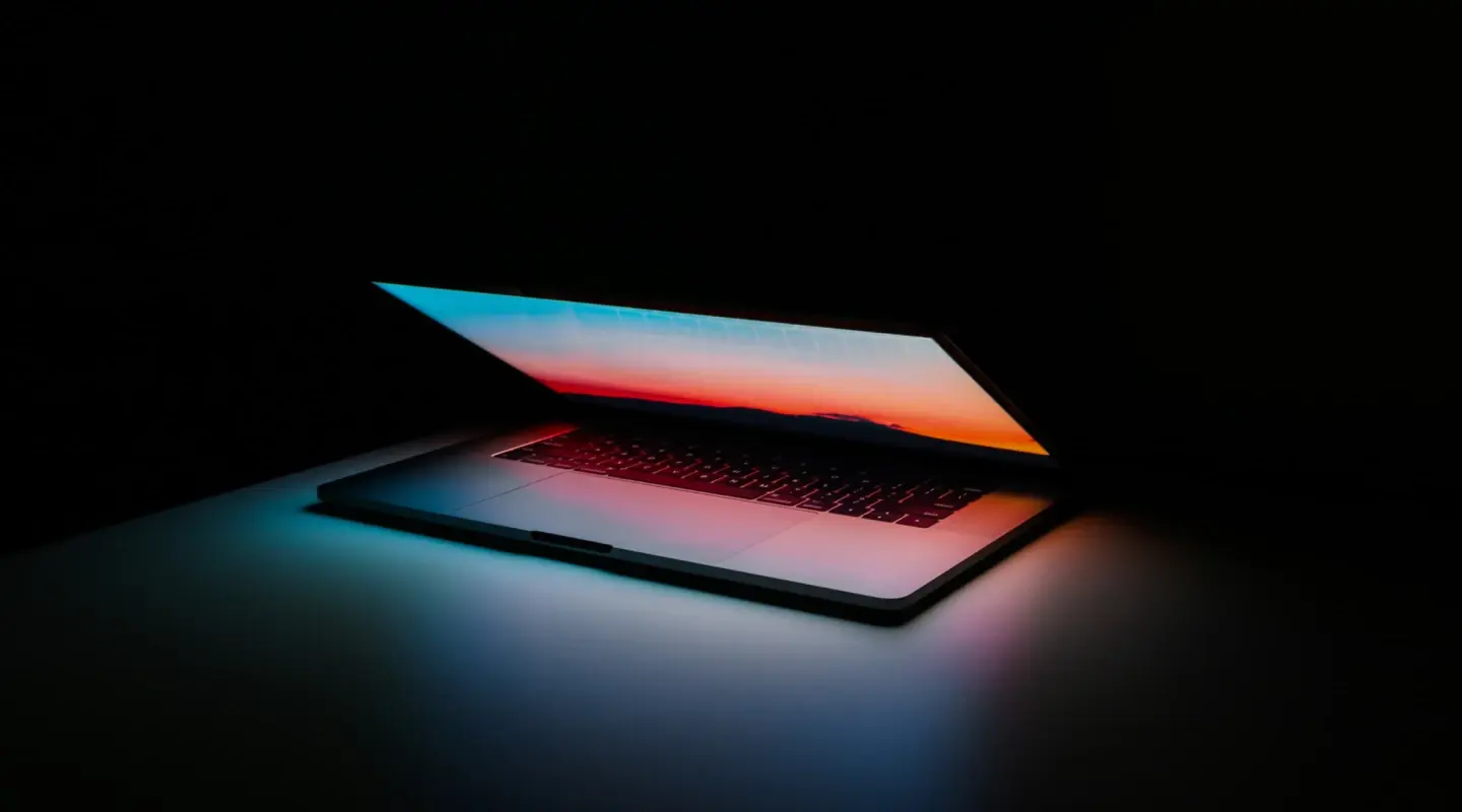 Open laptop with colorful screensaver against a black background