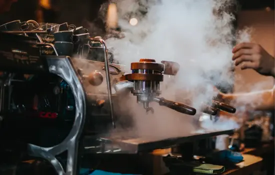 Espresso machine with steam pouring out of it