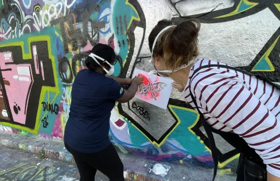 Two people doing graffiti art on a street in London