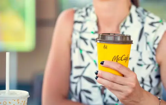 White person holds McDonald's fiber cup