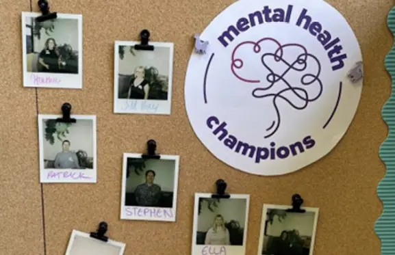 A bulletin board with pictures of tms' Mental Health Champions