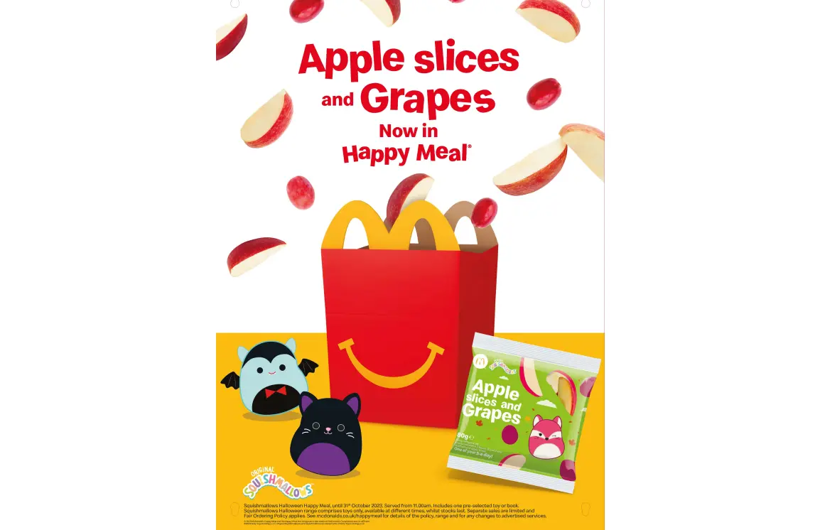 A Happy Meal box with two Squishmallows on the left and apples and grapes coming out of the top with the text "Apple slices and grapes now in Happy Meal