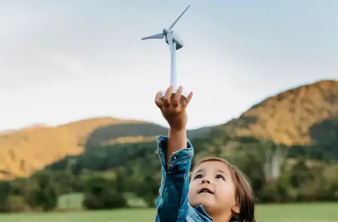 Child holding small wind turbine