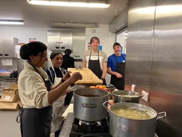 Volunteers cooking in a kitchen