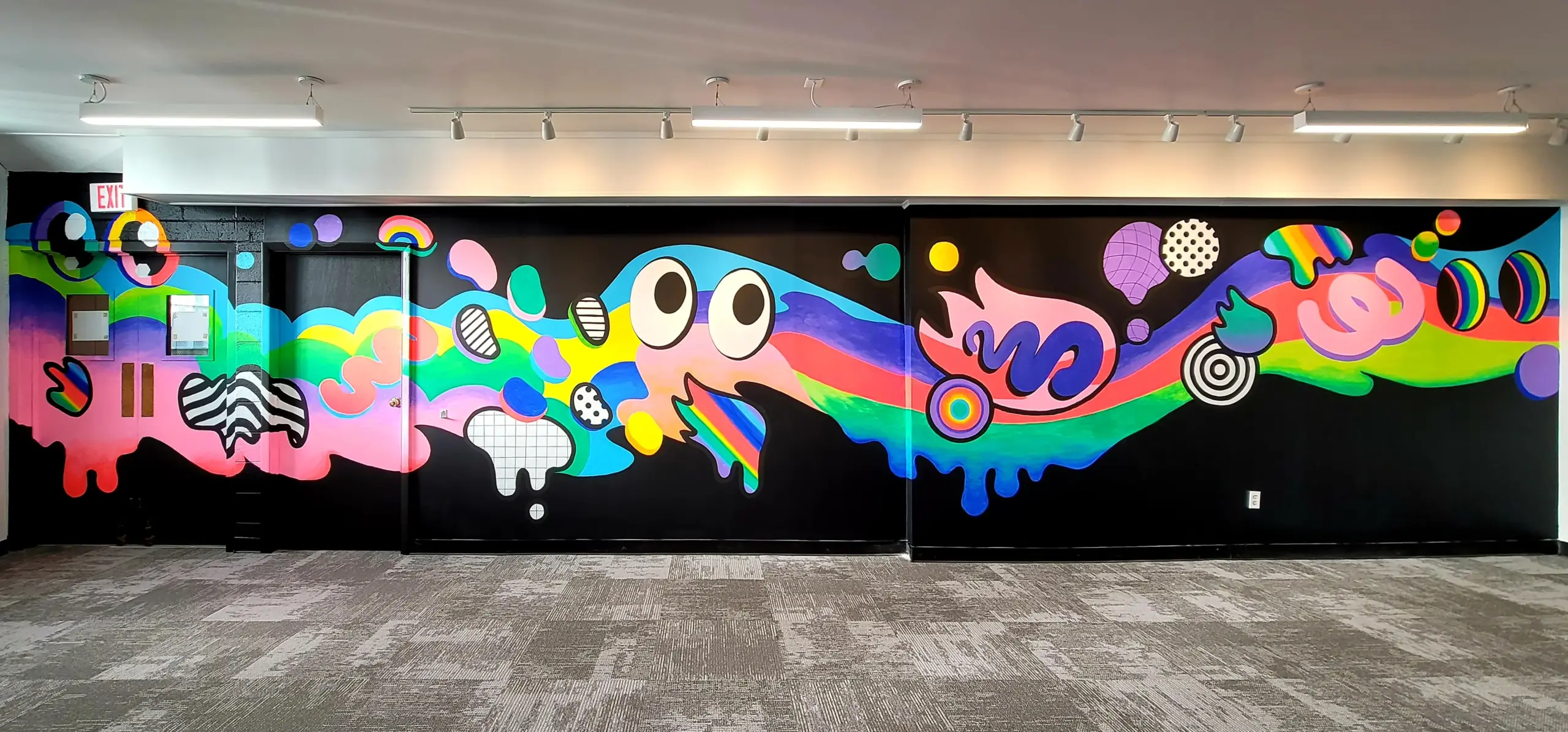Brightly coloured cartoon art mural on a black interior wall