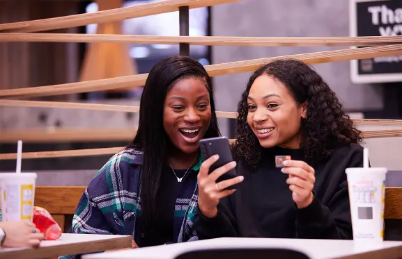 Deux femmes échangeant un prix du Monopoly Double Peel chez McDonald's