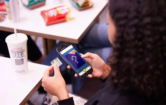 Woman holding a phone while playing the Double Peel MONOPOLY game