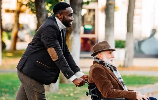 younger man pushing an older man in a wheel chair