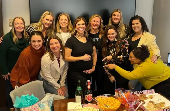 Pregnant Salazar posing with co-workers for work baby shower